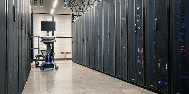 Rows of server racks in a modern data centre corridor