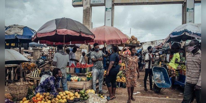 Shoppers and traders buying fruit and vegetables at a Nigerian food market.