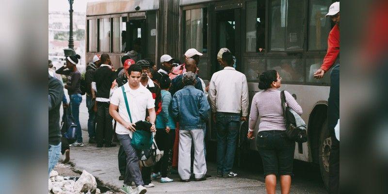 People boarding a public bus, used as illustrative commuter transport imagery.