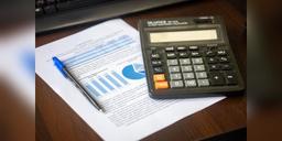 Calculator, pen and generic financial documents on a desk, used as illustrative financial paperwork.