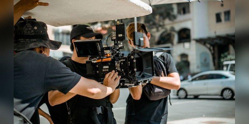 A film crew operating a professional camera on a city street, used as illustrative filmmaking imagery.