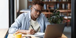 A Nigerian freelancer discussing project pricing with a client during an online meeting while reviewing a portfolio and contract.