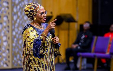 Sarah Omakwu kneeling on the pulpit during a sermon while appealing to Nyesom Wike over Jabi Lake development