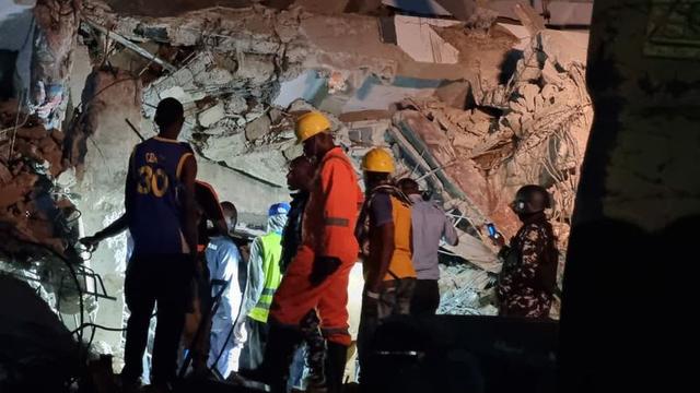 Rescue workers search through rubble of collapsed three-storey building on Borno Street, Yaba, Lagos, at night with emergency lights and equipment.