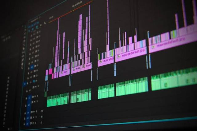 Beginner video editor working on a laptop with editing software, organising footage and adjusting audio for a content project.