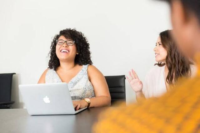 Content manager using project management, analytics, SEO and design tools on a laptop to plan and publish digital content.
