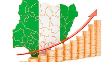 A Nigerian professional reviewing economic charts showing GDP growth, inflation and employment trends to understand their impact on income and jobs.