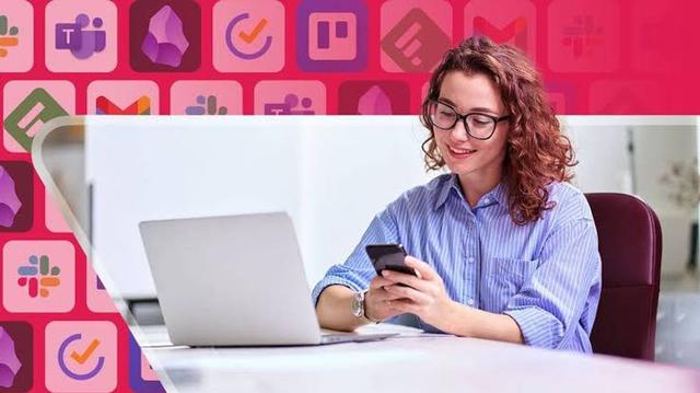 A remote worker using a smartphone and laptop with productivity apps open while working from a home office.