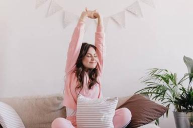 Person starting the day by drinking water, stretching near a sunny window and enjoying a healthy breakfast.
