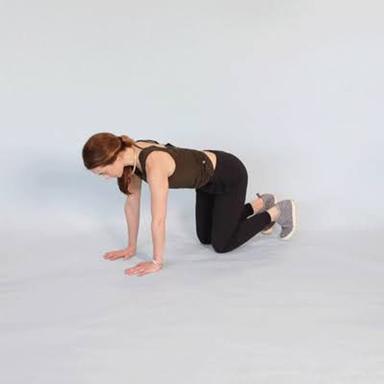 Person performing gentle lower back stretches on a yoga mat in a bright living room.
