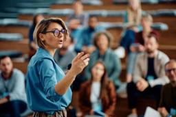 Beginner delivering a presentation to an audience while speaking confidently with simple presentation slides.
