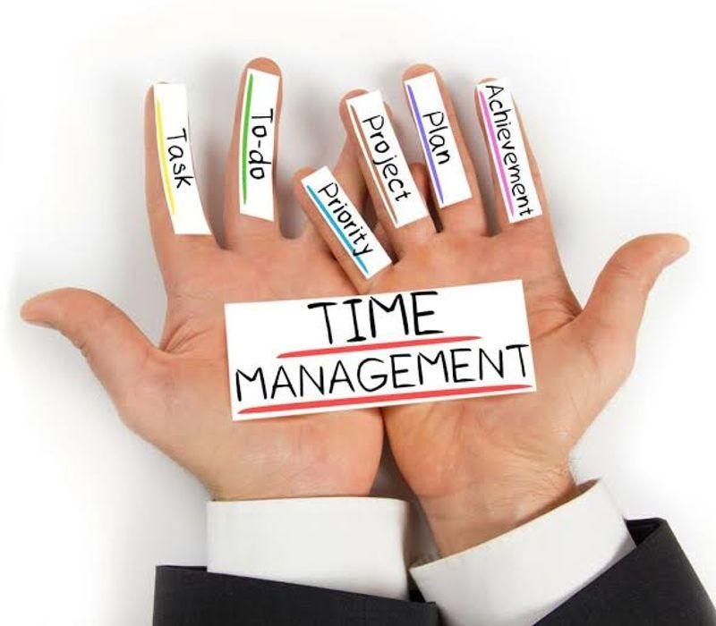 Professional organising daily tasks with a planner, laptop, calendar and clock in a productive workspace.