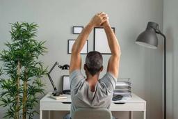 Office worker performing simple stretching exercises while seated at a desk during a work break.