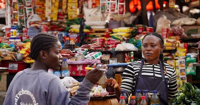 A food seller and shopper at a Lagos market.