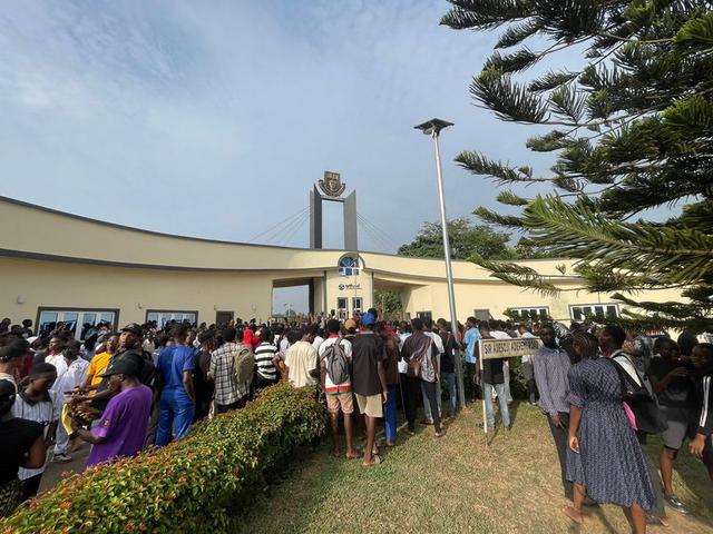 Students of Obafemi Awolowo University protesting at the campus main gate, holding banners and chanting during a peaceful demonstration.