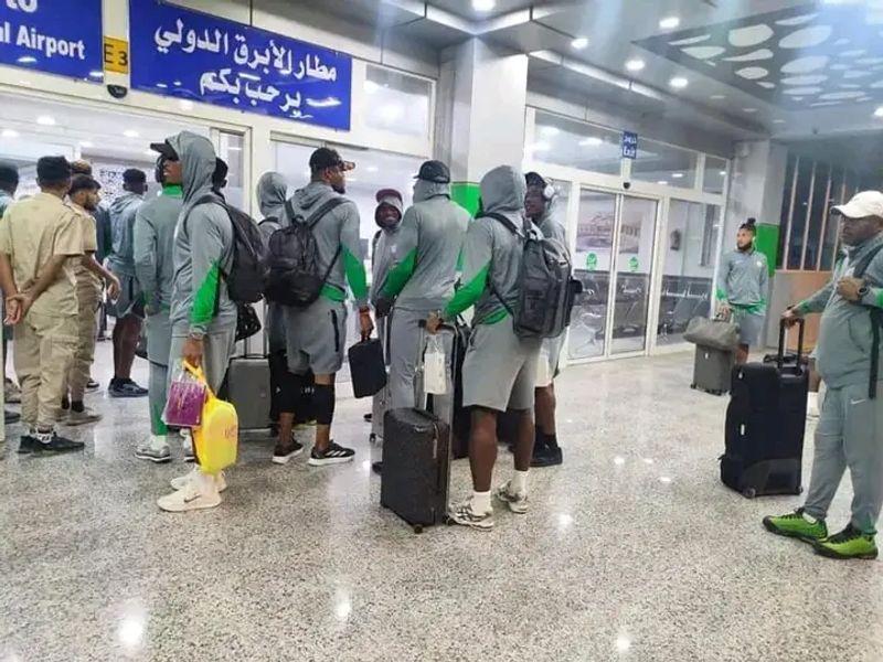 Super Eagles team members at Al Abraq International Airport, looking fatigued and frustrated after being stranded during travel to Libya
