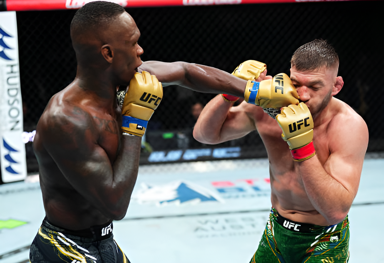 Image captures a UFC fight in action, with Israel Adesanya delivering a strong punch to his opponent, Du Plessis's face inside the octagon.