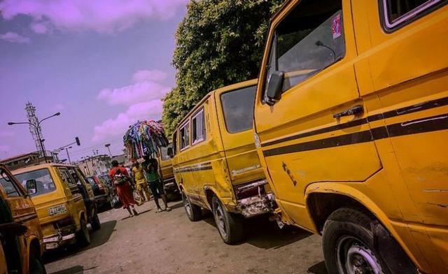 Busy Lagos street scene with commuters, yellow buses, roadside traders and city traffic, reflecting the hustle, resilience and energy of everyday Lagos life.