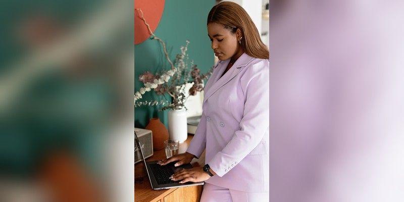 Entrepreneur in a lilac suit working on a laptop at a desk