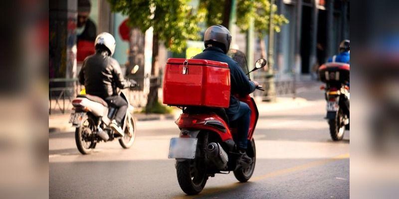 A dispatch rider carrying a delivery parcel on a Lagos street.