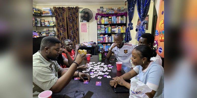 A group of players sits around a table playing a board game.