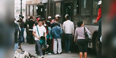People boarding a public bus, used as illustrative commuter transport imagery.