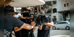 A film crew operating a professional camera on a city street, used as illustrative filmmaking imagery.