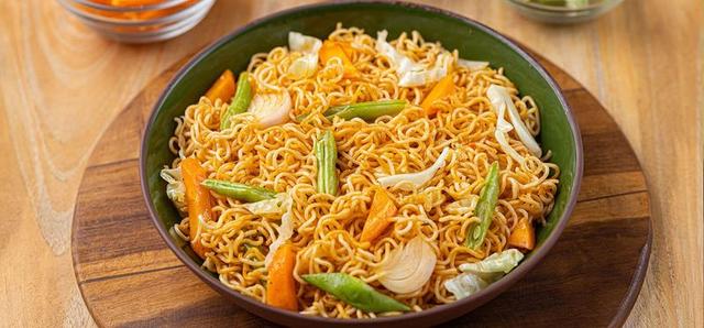 Packets of popular instant noodle brands in Nigeria, including Indomie, Golden Penny, Minimie, Honeywell and Mimee, displayed as affordable and convenient meal options.