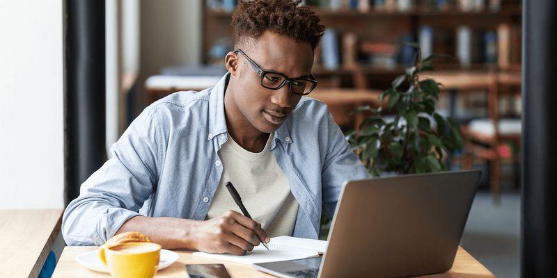 A Nigerian freelancer discussing project pricing with a client during an online meeting while reviewing a portfolio and contract.