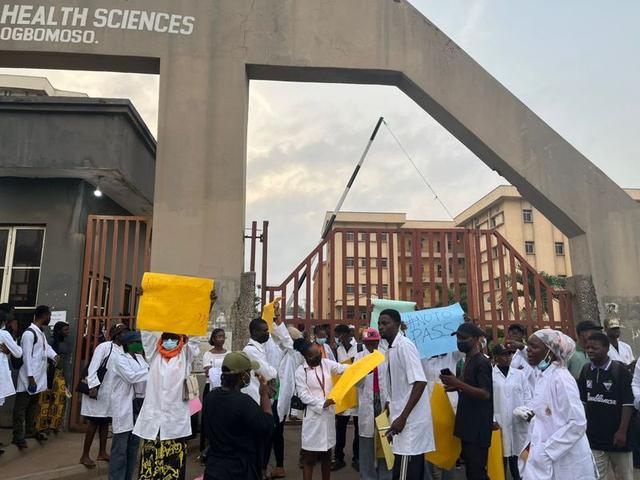 LAUTECH students blocking the main entrance in Ogbomoso while holding placards protesting the relocation of Anatomy and Physiology departments.