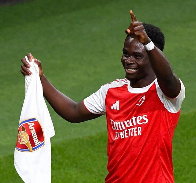 Bukayo Saka celebrating with Arsenal teammates after winning the Premier League title at London Colney training ground.