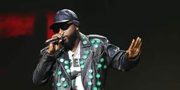 Davido performing on stage in a studded leather jacket and cap at a concert in Los Angeles