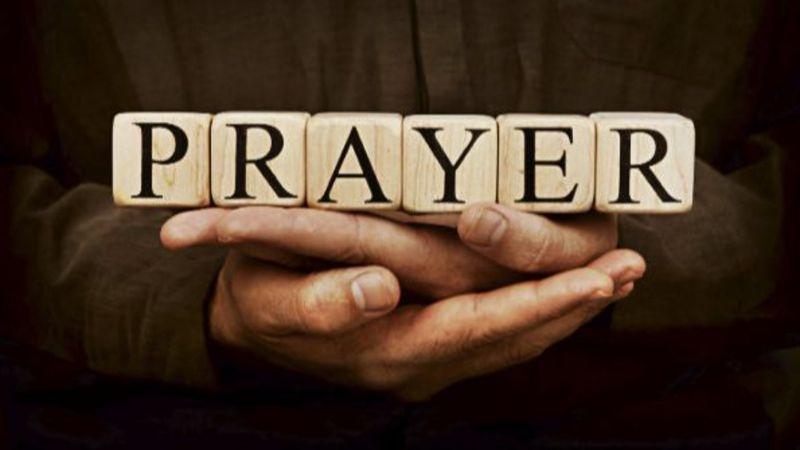 Christians participating in an early morning prayer livestream on a smartphone and laptop through online ministry platforms.