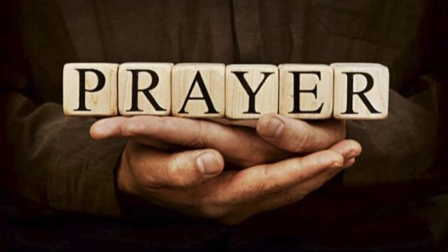 Christians participating in an early morning prayer livestream on a smartphone and laptop through online ministry platforms.