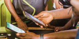 People using mobile banking apps on their smartphones in Nigeria