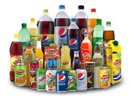 Bottles and cans of popular soft drinks in Nigeria, including Coca-Cola, Fanta, Sprite, Pepsi, 7UP, Mirinda and Schweppes, displayed on a table.