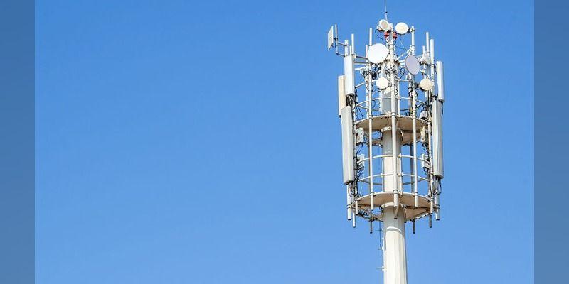 A telecommunications tower against a blue sky.