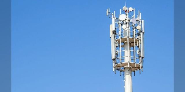 A telecommunications tower against a blue sky.