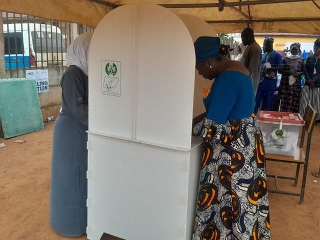 A voter casts a ballot beside an INEC ballot box at an Osun governorship election polling unit.