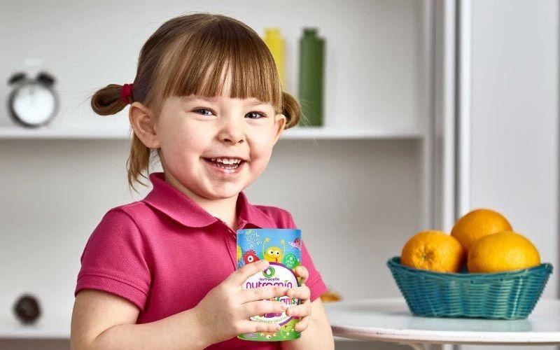 Happy child enjoying a colourful bowl of fresh fruit and a homemade smoothie rich in vitamin C.